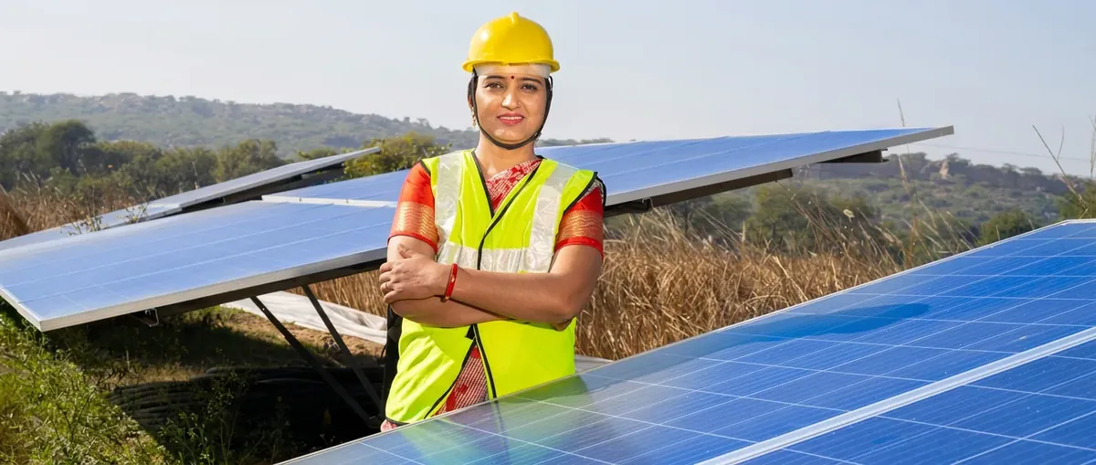 Woman solar professional standing among solar panels